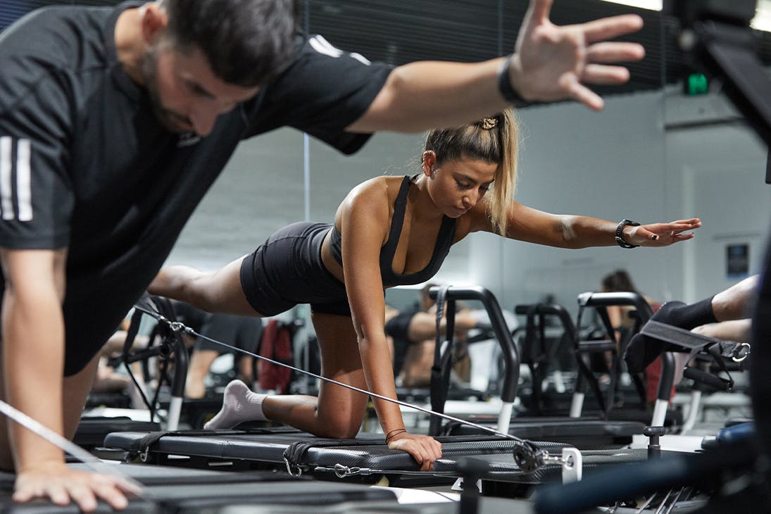 people doing exercise on a reformer bed